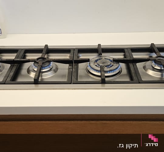 כיריים גז עם להבות דולקות על משטח מטבח